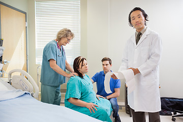 Image showing Doctor Explaining Fetal Heartbeat Report To Pregnant Woman In Ho