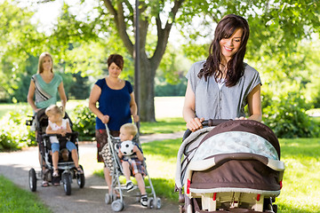 Image showing Mother Looking At Baby In Stroller At Park