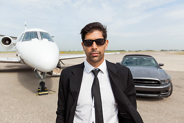 Image showing Entrepreneur In Front Of Car And Private Jet