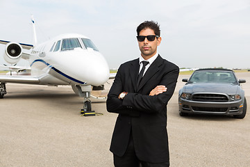 Image showing Businessman Standing In Front Of Car And Private Jet