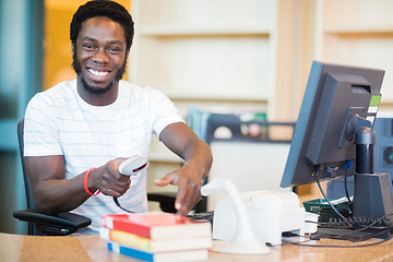 Image showing Happy Librarian Scanning Books In Library