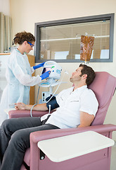 Image showing Patient Looking At Nurse Operating Heartbeat Machine