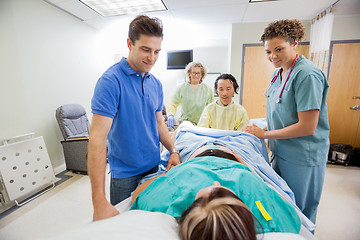 Image showing Medical Team And Husband Looking At Pregnant Woman