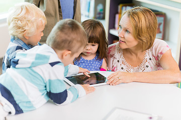 Image showing Teacher With Students Using Digital Tablet In Library