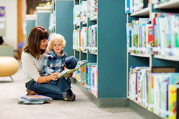 Image showing Boy With Teacher Reading Book In Library