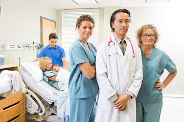 Image showing Successful Medical Team With Newborn Baby And Parents In Backgro