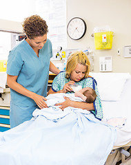 Image showing Nurse Looking At Patient Feeding Milk To Baby At Hospital