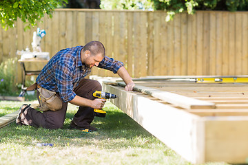 Image showing Carpenter Drilling Wood At Construction Site