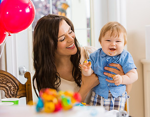 Image showing Mother Holding Baby Boy At Birthday Party