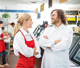 Image showing Happy Butchers Looking At Each Other In Store