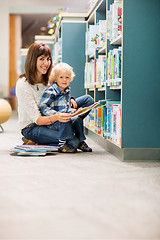 Image showing Happy Teacher And Boy Reading Book In Library