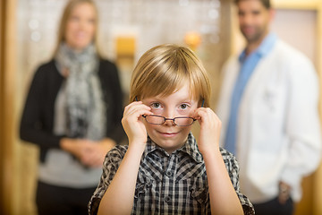 Image showing Boy Trying Eyeglasses With Optometrist And Mother At Store