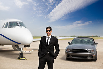 Image showing Entrepreneur Standing In Front Of Car And Private Jet