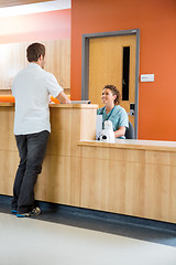 Image showing Patient Conversing With Nurse At Reception Desk