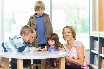 Image showing Teacher With Students Using Tablet Computer In Library