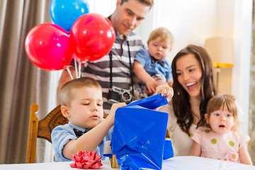 Image showing Family Looking At Birthday Boy Opening Gift Box