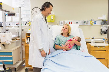 Image showing Mother Holding Newborn Babygirl While Looking At Doctor