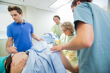 Image showing Medical Team Examining Pregnant Woman During Delivery In Operati