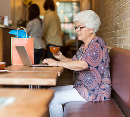 Image showing Senior Woman Using Laptop While Having Coffee In Cafeteria