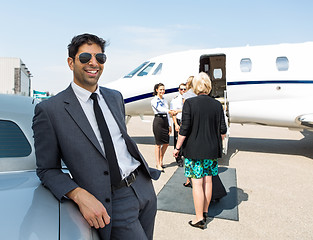 Image showing Happy Businessman Leaning On Car At Airport Terminal