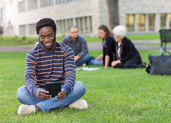 Image showing Student Using Digital Tablet On Grass At Campus Park