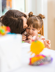 Image showing Mother Kissing Girl Eating Cupcake