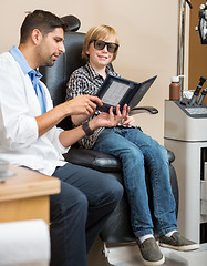 Image showing Boy Smiling While Optometrist Holding Test Chart