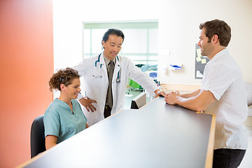 Image showing Medical Team Working On Computer While Man Standing At Reception