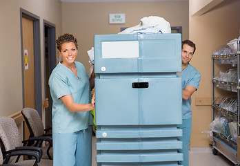 Image showing Nurses Pushing Trolley Filled With Linen In Hospital Hallway