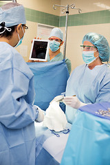 Image showing Nurse Showing Digital Tablet To Doctor During Surgery