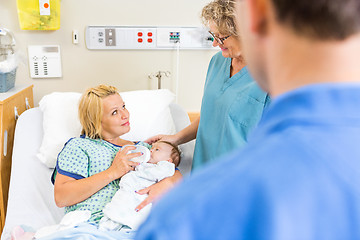 Image showing Nurse Looking At Woman Feeding Milk To Babygirl In Hospital