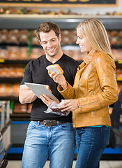 Image showing Couple Using Digital Tablet While Purchasing Meat