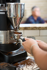 Image showing Barista Grinding Coffee