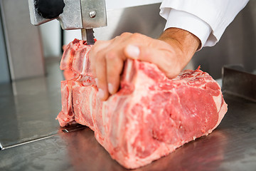 Image showing Hand Slicing Meat On Bandsaw