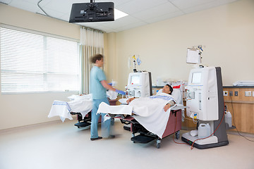 Image showing Nurse Walking By Patient Receiving Renal Dialysis