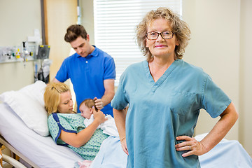 Image showing Mature Nurse Standing With Couple And Newborn Baby In Background