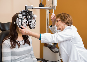 Image showing Optometrist Examining Young Woman's Eyes