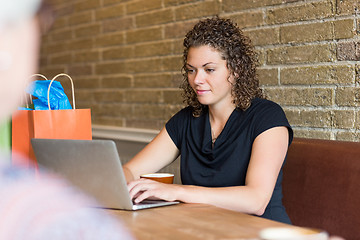 Image showing Woman Using Laptop At Table In Cafeteria