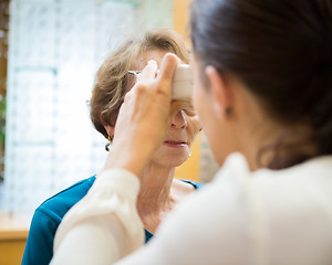 Image showing Optometrist Examining Senior Woman's Vision