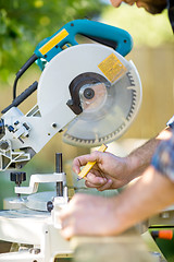 Image showing Carpenter's Hands Marking On Wood At Table Saw