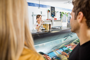 Image showing Saleswoman Looking At Customers In Butcher's Shop