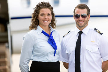 Image showing Stewardess And Pilot Standing Against Private Jet