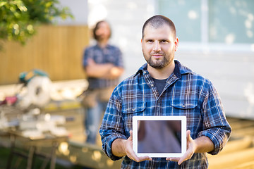 Image showing Confident Carpenter Displaying Digital Tablet With Coworker In B