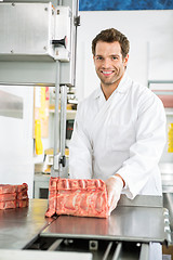 Image showing Butcher Slicing Meat On Bandsaw