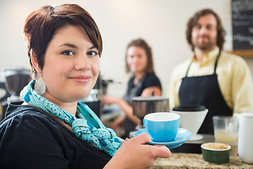 Image showing Woman Holding Coffee Cup With Owners in cafe