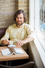 Image showing Man With Coffee Cup And Book In Cafeteria