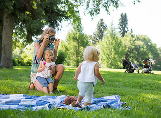 Image showing Mother Photographing Daughter In Park