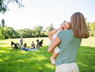 Image showing Mother Carrying Cheerful Daughter In Park