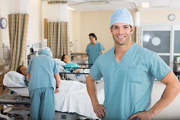 Image showing Male Nurse With Colleagues Examining Patient's