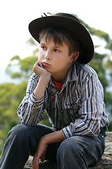 Image showing Country cowboy sitting on a rock